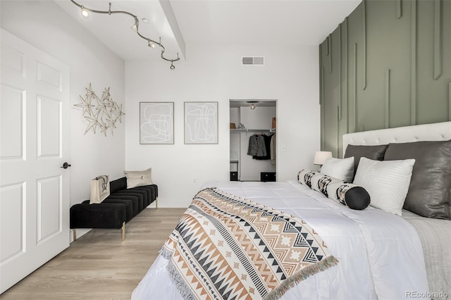 bedroom with a closet, a walk in closet, and light hardwood / wood-style flooring