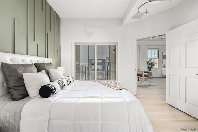 bedroom with access to outside and light wood-type flooring