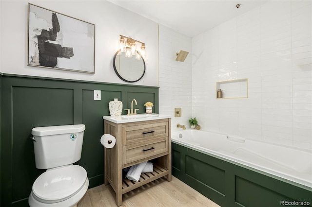 bathroom featuring hardwood / wood-style floors, vanity, toilet, and a tub to relax in