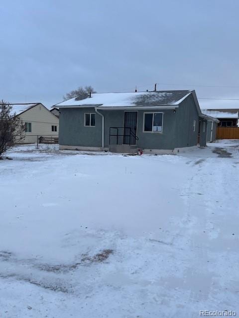 view of snow covered back of property