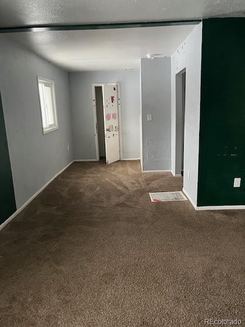 carpeted empty room with a textured ceiling