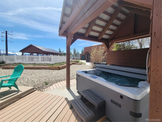 deck with a gazebo, a patio, and a hot tub