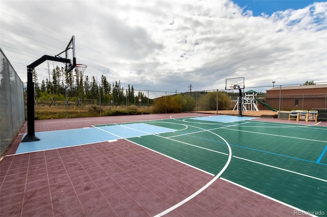 view of basketball court with a playground