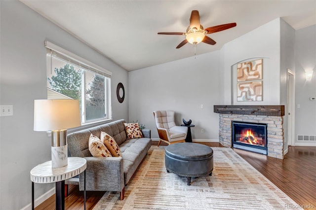 2132 Boise Ct, Longmont, CO 80504 - living area with wood finished floors, a ceiling fan, baseboards, a stone fireplace, and vaulted ceiling