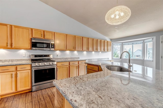 2132 Boise Ct, Longmont, CO 80504 - kitchen with stainless steel appliances, a sink, vaulted ceiling, light brown cabinetry, and light stone countertops