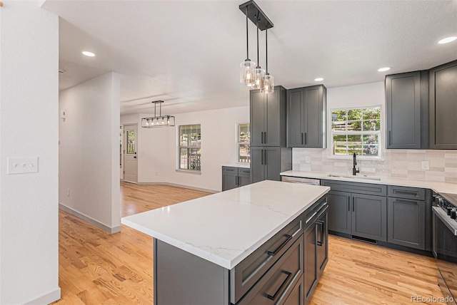 9948 King St, Westminster, CO 80031 - kitchen featuring light wood-style flooring, tasteful backsplash, a chandelier, a center island, and pendant lighting