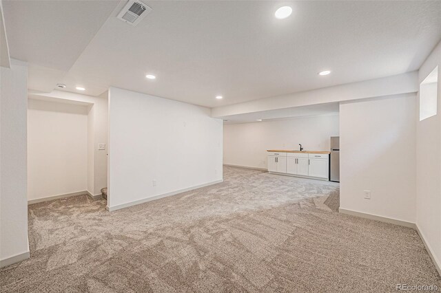 9948 King St, Westminster, CO 80031 - finished basement with recessed lighting, light carpet, and freestanding refrigerator