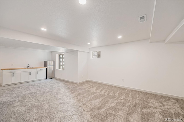 9948 King St, Westminster, CO 80031 - basement with freestanding refrigerator, light carpet, and recessed lighting
