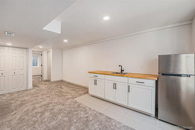 9948 King St, Westminster, CO 80031 - kitchen with freestanding refrigerator, butcher block counters, light carpet, white cabinetry, and recessed lighting