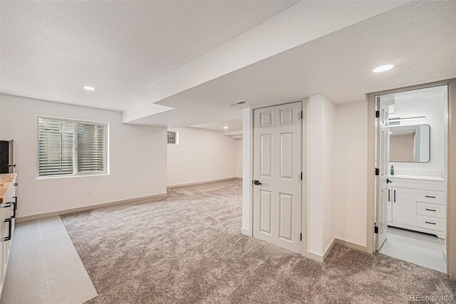 9948 King St, Westminster, CO 80031 - below grade area with light carpet, a textured ceiling, and recessed lighting