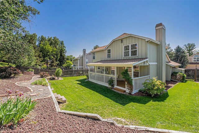9948 King St, Westminster, CO 80031 - back of house featuring a chimney, board and batten siding, a fenced backyard, and covered porch