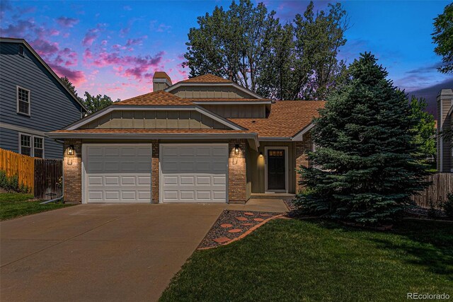 9948 King St, Westminster, CO 80031 - view of front facade with an attached garage, driveway, brick siding, and board and batten siding