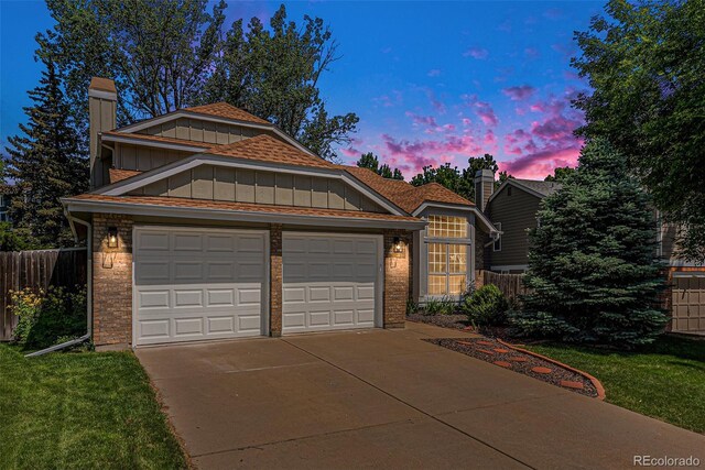9948 King St, Westminster, CO 80031 - view of front of property featuring board and batten siding, concrete driveway, brick siding, and an attached garage