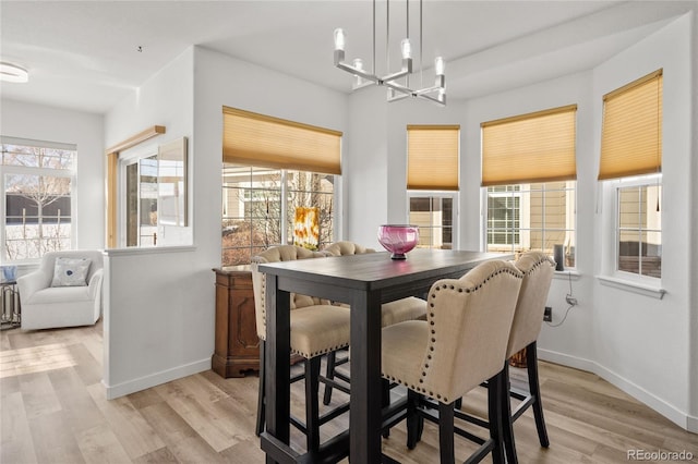 dining area featuring a wealth of natural light, light hardwood / wood-style floors, and a chandelier