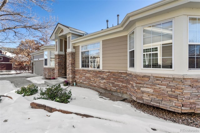 view of snowy exterior featuring a garage