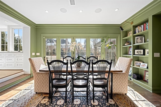 dining space featuring plenty of natural light, ornamental molding, and dark wood-type flooring