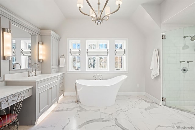 full bath with baseboards, marble finish floor, vanity, a freestanding tub, and a shower stall