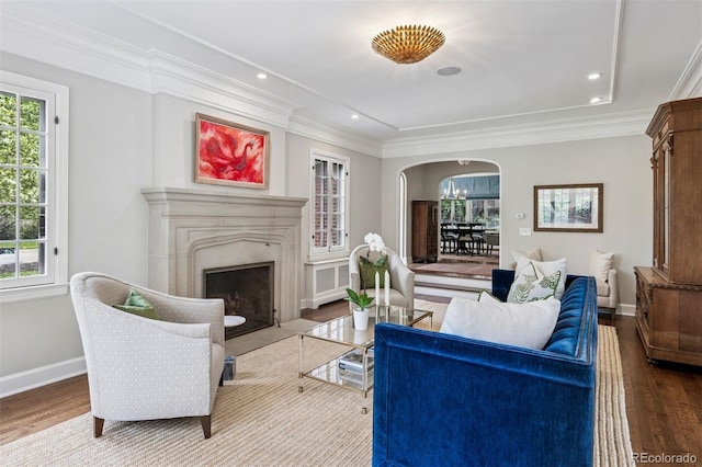 living room featuring a wealth of natural light, baseboards, arched walkways, and wood finished floors
