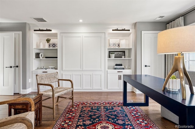 office featuring visible vents, wood finished floors, and built in features