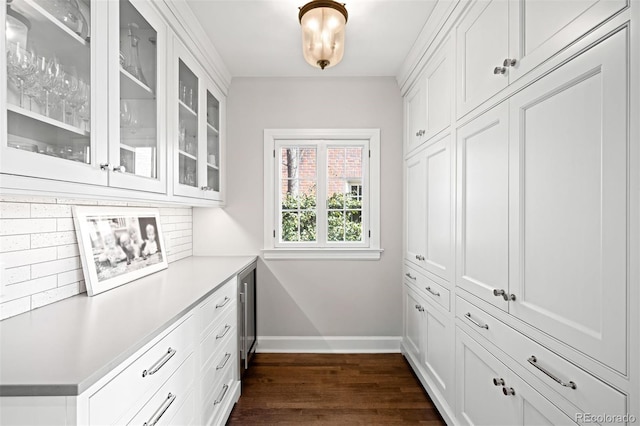 interior space featuring beverage cooler, decorative backsplash, baseboards, and dark wood-style floors