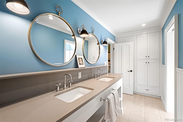 bathroom with a sink, double vanity, ornamental molding, and recessed lighting