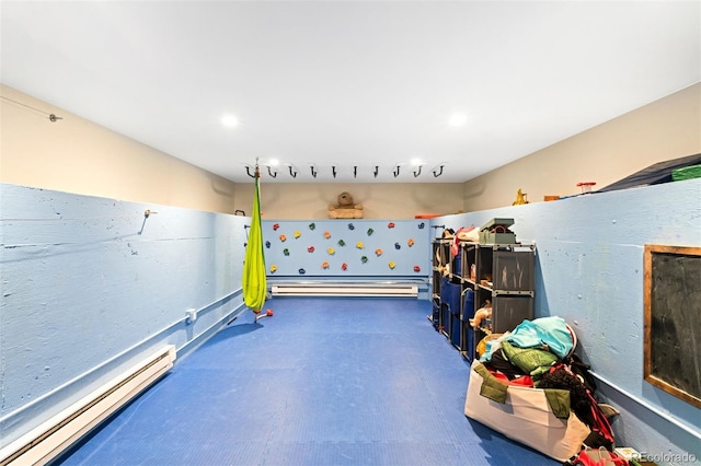 recreation room featuring concrete flooring, baseboard heating, and a baseboard heating unit