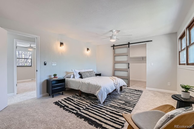 4682 Chatham St, Boulder, CO 80301 - bedroom featuring a barn door, light colored carpet, multiple windows, a ceiling fan, and a textured ceiling
