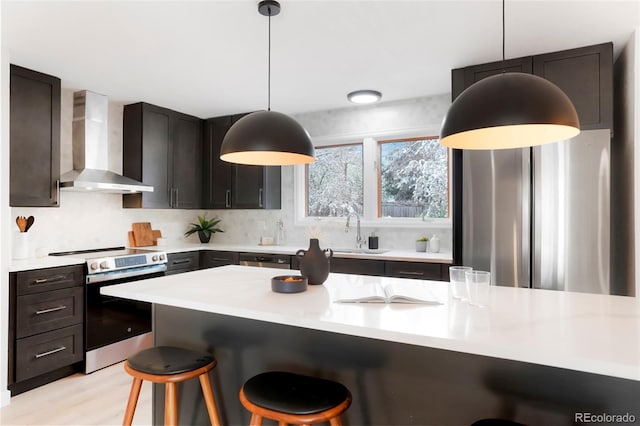4682 Chatham St, Boulder, CO 80301 - kitchen featuring wall chimney range hood, stainless steel appliances, a sink, a breakfast bar area, and light countertops