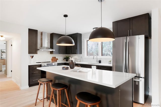 4682 Chatham St, Boulder, CO 80301 - kitchen with wall chimney range hood, appliances with stainless steel finishes, a kitchen bar, and light countertops