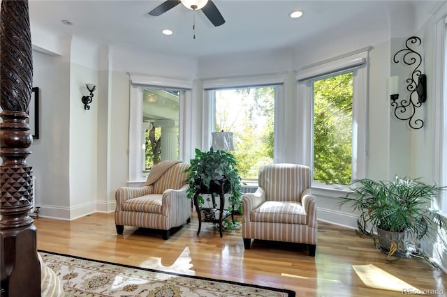 living area with light hardwood / wood-style floors and ceiling fan