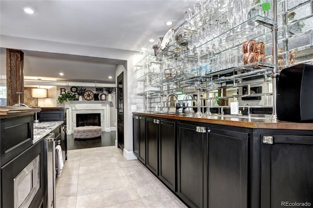 bar featuring sink, beverage cooler, and light tile patterned floors