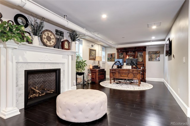 sitting room featuring a premium fireplace and dark hardwood / wood-style floors