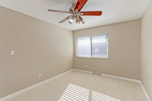 carpeted empty room with ceiling fan and a textured ceiling