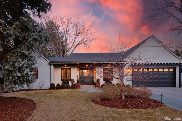 single story home featuring a garage and a yard