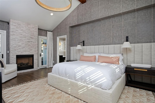 bedroom featuring hardwood / wood-style flooring, a fireplace, high vaulted ceiling, and beam ceiling