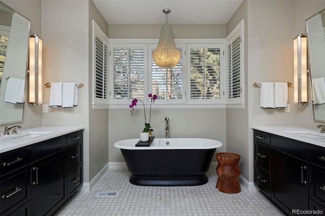 bathroom featuring tile patterned flooring, vanity, and a bath