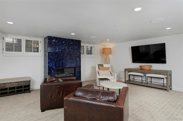 living room featuring a tiled fireplace and carpet