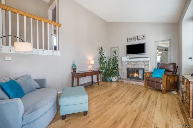 8893 W Ontario Ave, Littleton, CO 80128 - living area with a glass covered fireplace, wood finished floors, and lofted ceiling