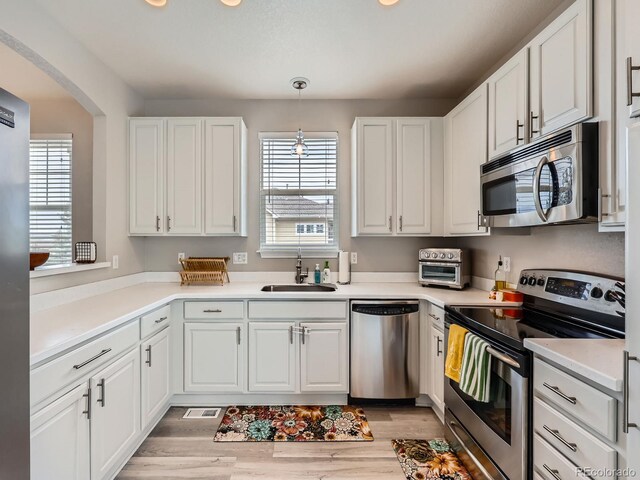 9363 Amison Cir Unit 106, Parker, CO 80134 - kitchen featuring stainless steel appliances, a sink, white cabinets, light wood-style floors, and recessed lighting