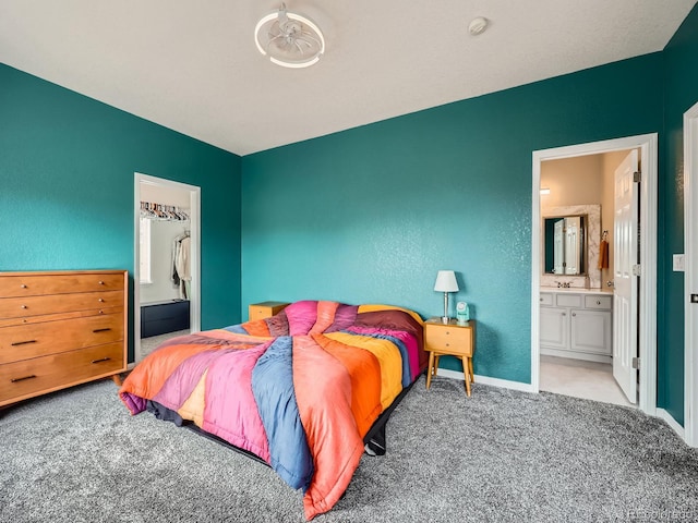 9363 Amison Cir Unit 106, Parker, CO 80134 - carpeted bedroom featuring ensuite bathroom, baseboards, and a textured wall