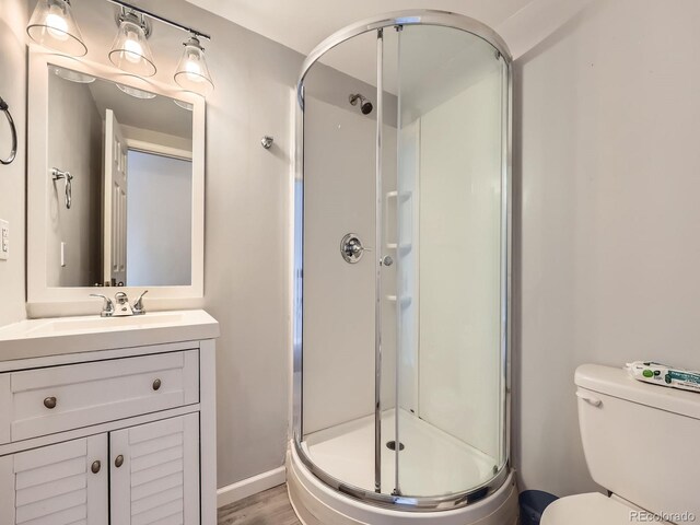 9363 Amison Cir Unit 106, Parker, CO 80134 - full bathroom featuring a shower stall, vanity, toilet, and wood finished floors