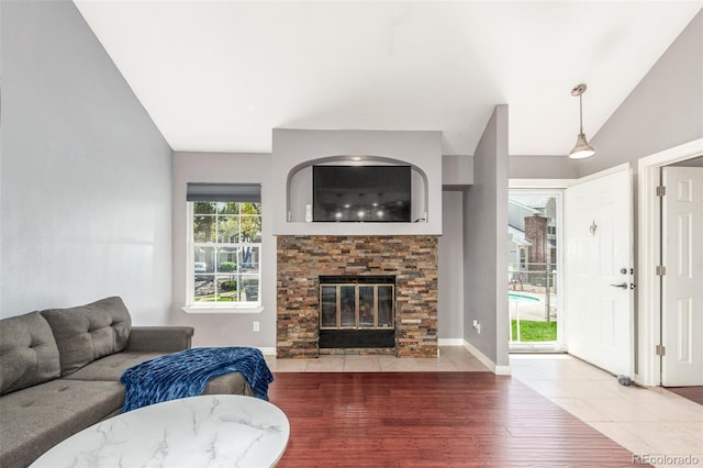 living area with a fireplace, wood finished floors, and lofted ceiling