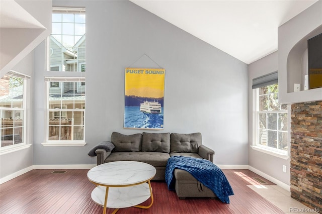 living room with baseboards, vaulted ceiling, and wood finished floors