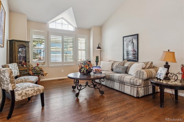 living room featuring baseboards, wood finished floors, and vaulted ceiling