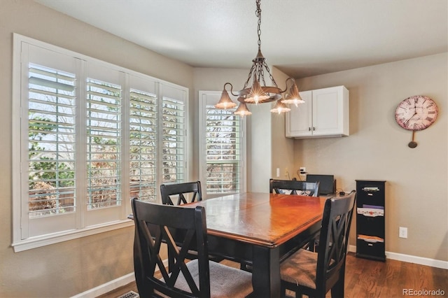 dining room featuring baseboards, dark wood-style flooring, and a chandelier