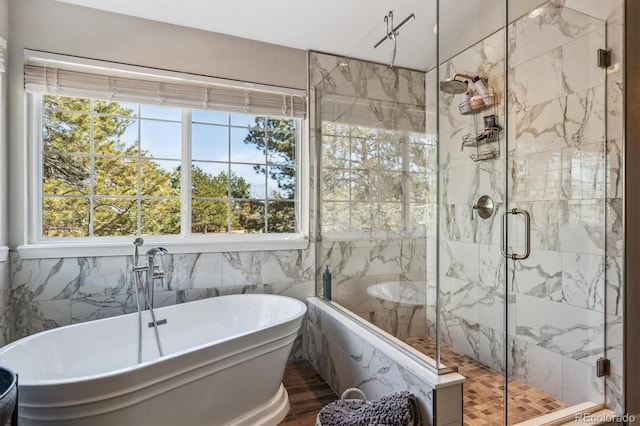 full bath featuring a marble finish shower and a soaking tub