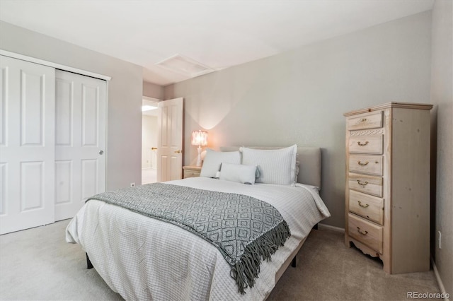 bedroom featuring attic access, light colored carpet, and a closet