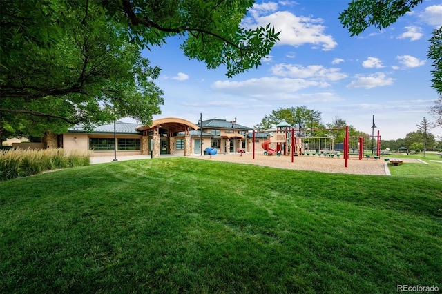 rear view of property featuring a yard, playground community, and metal roof