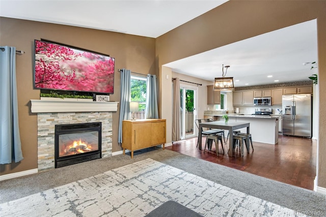 1179 S Alton Ct, Denver, CO 80247 - dining space with dark carpet, a stone fireplace, baseboards, and recessed lighting