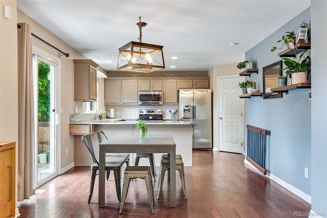 1179 S Alton Ct, Denver, CO 80247 - kitchen featuring appliances with stainless steel finishes, a peninsula, a chandelier, recessed lighting, and dark wood-type flooring